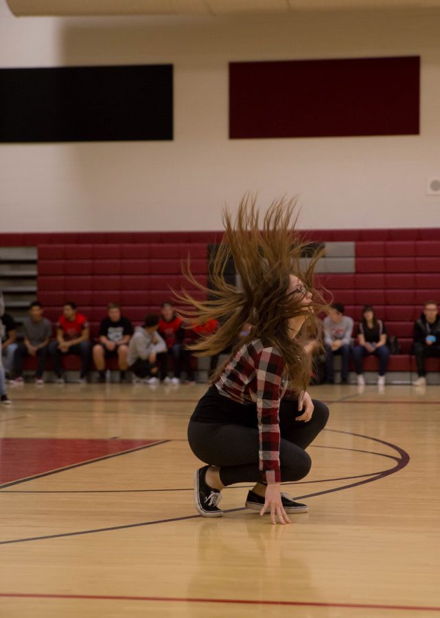 Senior Rebecca Shaw shows off her hair flips and the RUSH dance company routine at the eighth grade assembly. 