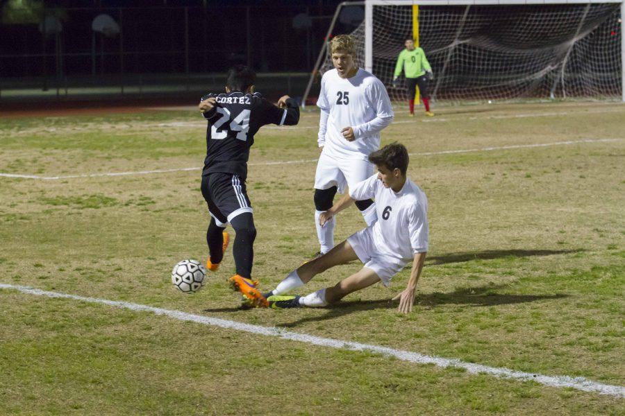 Combs Middle Fielder Doug Geng kicking the ball away from Coronado forward Irving Cazares, a strong 
effort in a losing game.