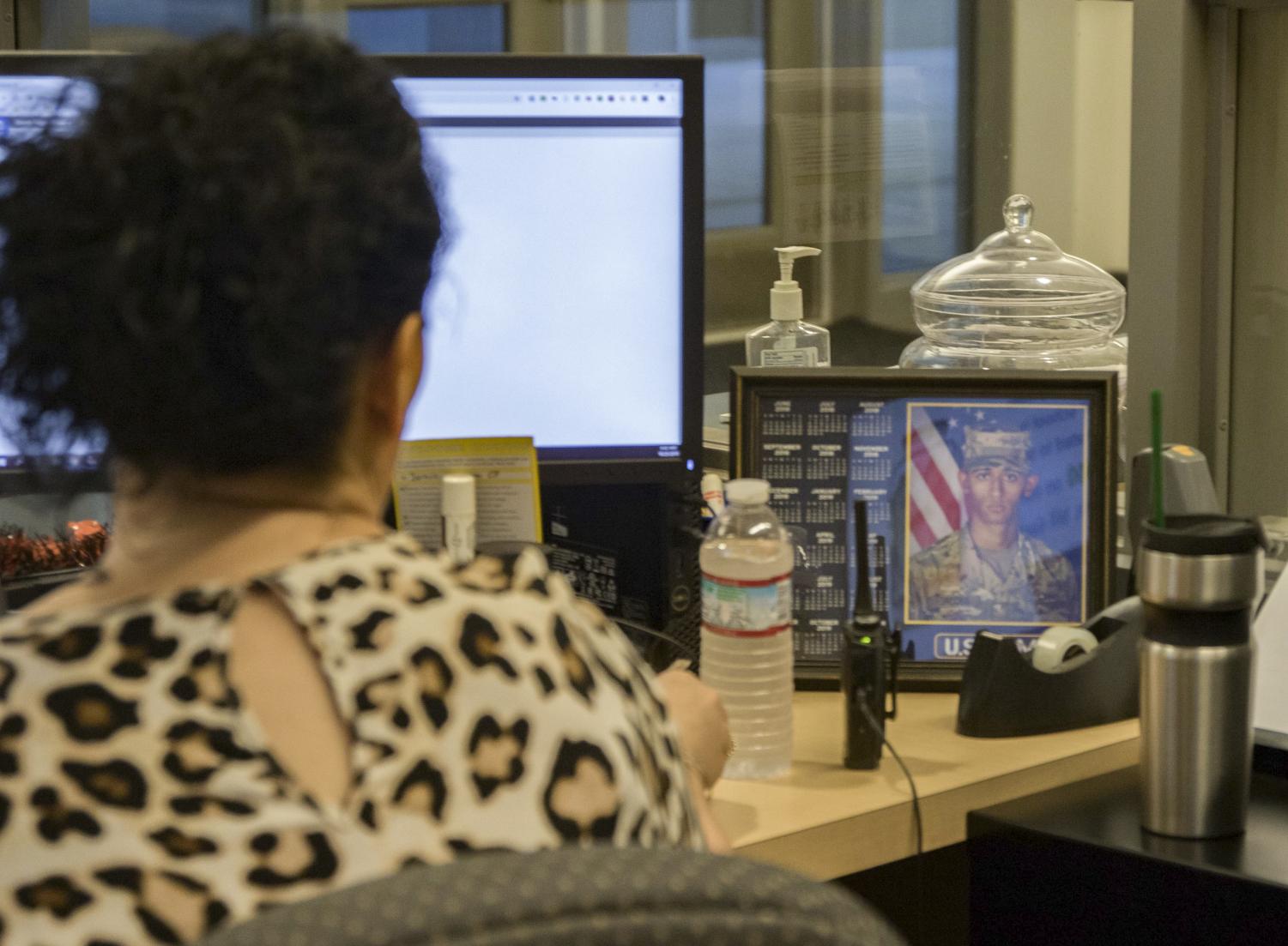 Still By Her Side: Attendance Clerk Bernice Jacobs takes a glance at a photo of her son Nathan who is now serving in the US Army. It was Jacobs’ strong bond with her son that led her to accept the Attendance Clerk position at CHS.