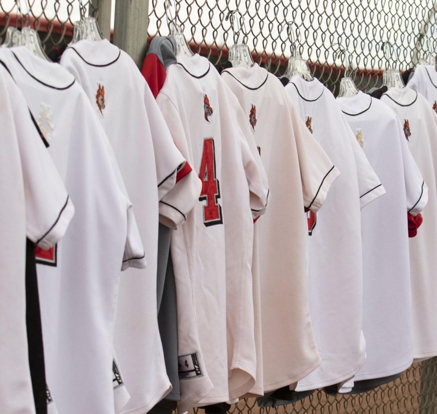 Varsity jerseys hanging from the fence.