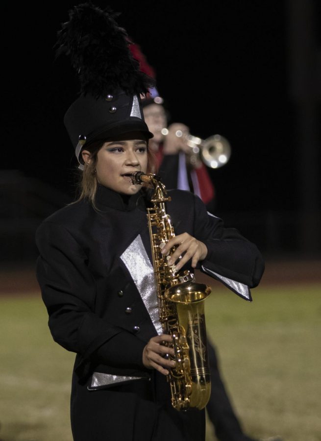 Senior Sophia Apostol plays a solo during half time on her saxophone  as the rest of band and color guard are performing.